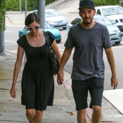 Mike Shinoda and his wife, Anna Shinoda walking on the street while holding each other hands.